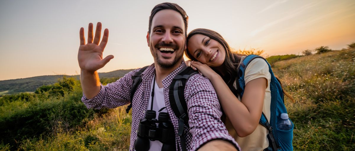 Geschenke für Wanderer, Paar beim Wandern lächelt in Kamera