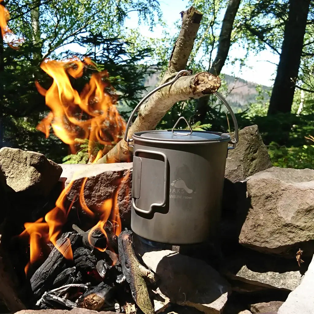 Der TOAKS Titan Kochtopf mit Bail Handle 750ml im Einsat - man sieht wie sich der Bail Handle dazu eignet, den Topf auf offenem Feuer zu verwenden