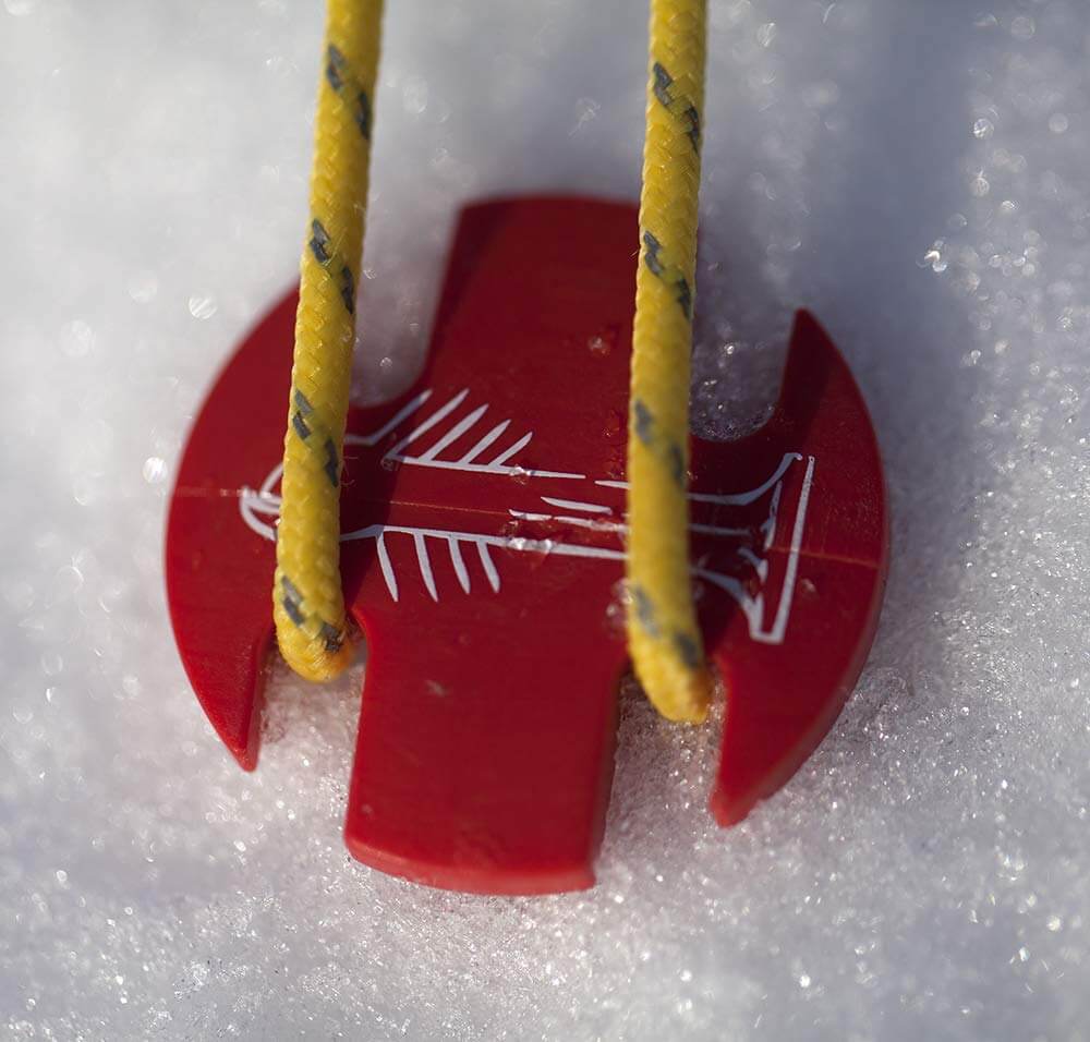 Hier ist einer der Zeltheringe – SwissPiranha – RT220 – 6er-Set im Schnee eingeschlagen