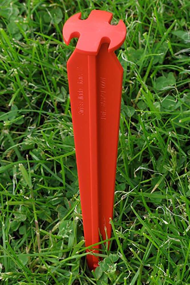 Hier ist einer der Zeltheringe – SwissPiranha – RT220 – 6er-Set in eine Wiese eingeschlagen